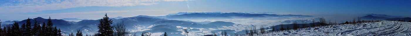 Zimowa panorama ze szczytu Ćwilina: Pasmo Radziejowej, Magura Spiska i szczyty tatrzańskie (Gerlach, Krywań, Kozi Wierch, Świnica) na horyzoncie, po prawej Kotlina Rabczańska, Babia Góra i Polica, w dolinach mgły.