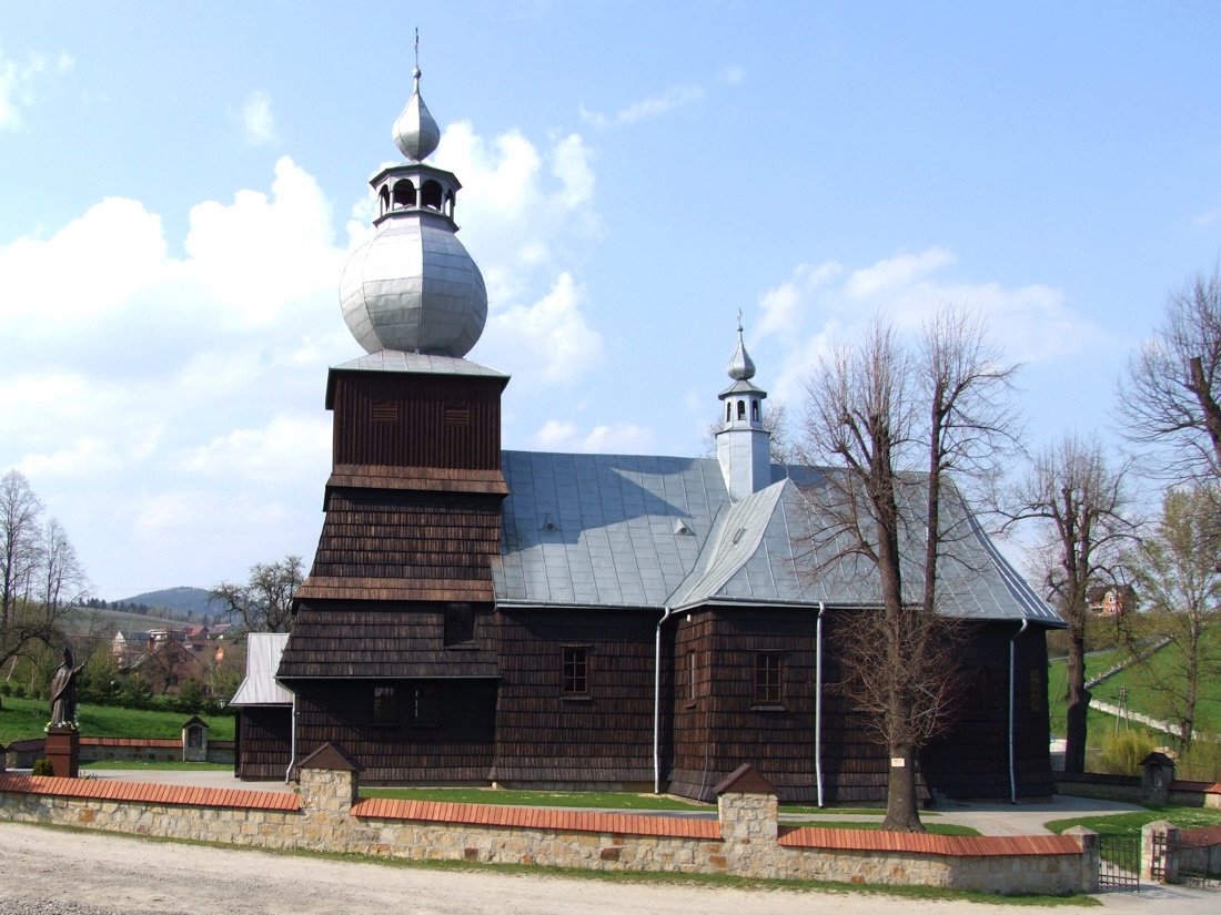 Widok od zachodu w 2011 roku, po remoncie: drewniana dzwonnica z baniastym hełmem i latarnią, obok bryła kościoła.